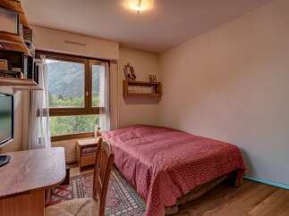 This cozy bedroom offers a comfortable single bed with a striking red patterned duvet, perfect for a peaceful retreat.