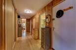 Step into this charming hallway featuring warm wood-paneled walls and a polished hardwood floor, creating a cozy and inviting atmosphere.