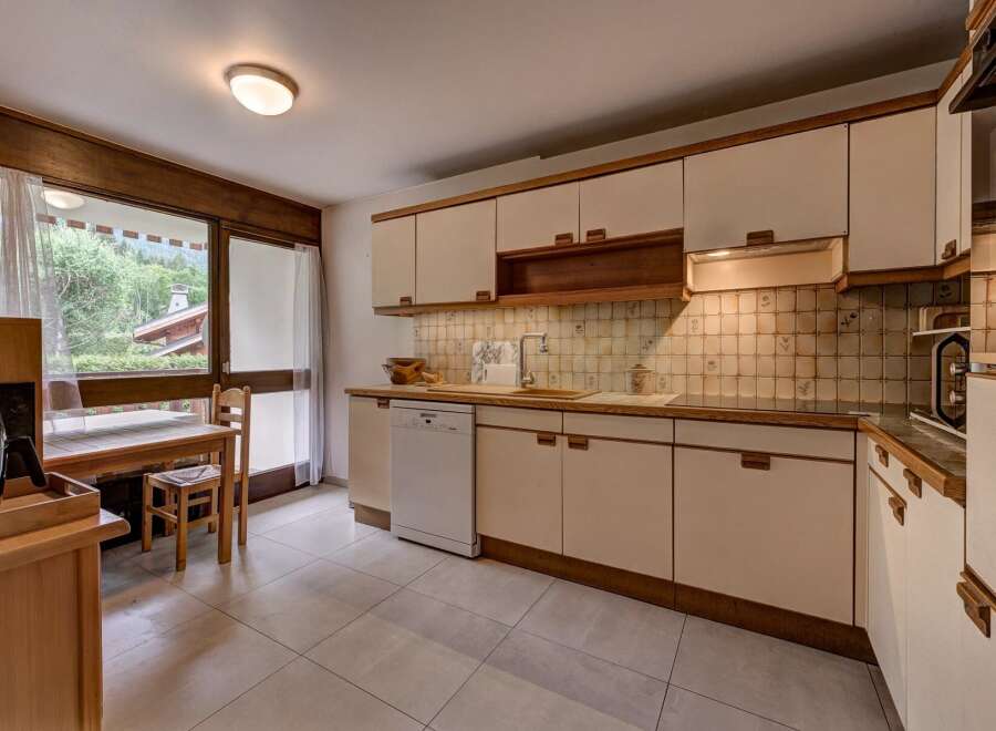 This charming kitchen features light-colored cabinetry and wooden countertops, complemented by a tiled backsplash.