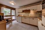 This charming kitchen features light-colored cabinetry and wooden countertops, complemented by a tiled backsplash.