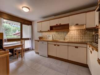This charming kitchen features light-colored cabinetry and wooden countertops, complemented by a tiled backsplash.