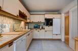 This charming kitchen features a practical layout with ample cabinet space and a built-in oven and microwave.
