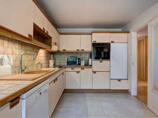 This charming kitchen features a practical layout with ample cabinet space and a built-in oven and microwave.