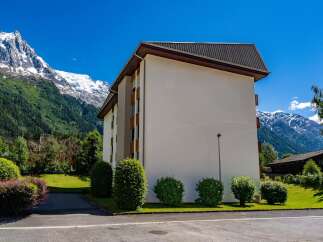 Experience alpine living in this modern building nestled against a backdrop of majestic snow-capped mountains and lush green forests.