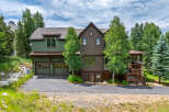 Discover this stunning mountain home featuring a charming green exterior and a rich brown shingle facade, complemented by a rustic wood-shingled roof.