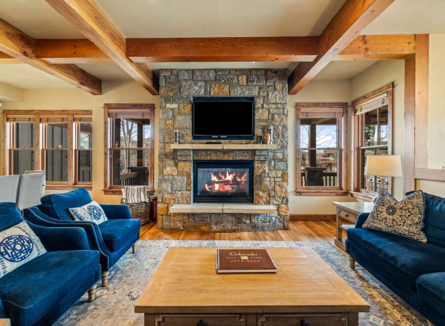 Experience rustic luxury in this stunning living room, featuring a grand stone fireplace as the centerpiece.