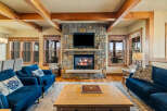 Experience rustic luxury in this stunning living room, featuring a grand stone fireplace as the centerpiece.