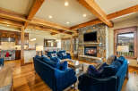 Experience luxurious mountain living in this stunning great room, featuring a grand stone fireplace and exposed wooden beams that add rustic charm.