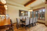 Experience elegant dining in this spacious room, featuring a large wooden table surrounded by upholstered chairs, perfect for hosting gatherings.