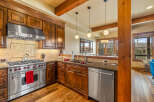 Experience luxury mountain living in this stunning kitchen, featuring rich wood cabinetry, granite countertops, and a professional-grade stainless steel range.