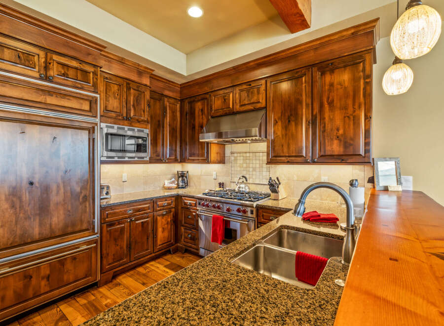 Experience luxury in this stunning kitchen featuring custom wood cabinetry and granite countertops.