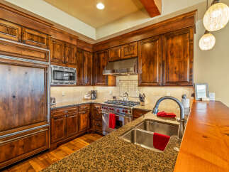 Experience luxury in this stunning kitchen featuring custom wood cabinetry and granite countertops.