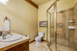 This bathroom features a spacious walk-in shower with elegant tile work and a built-in shelf for toiletries.