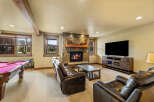 Experience ultimate relaxation in this cozy basement living area, featuring a stone fireplace and plush leather seating.