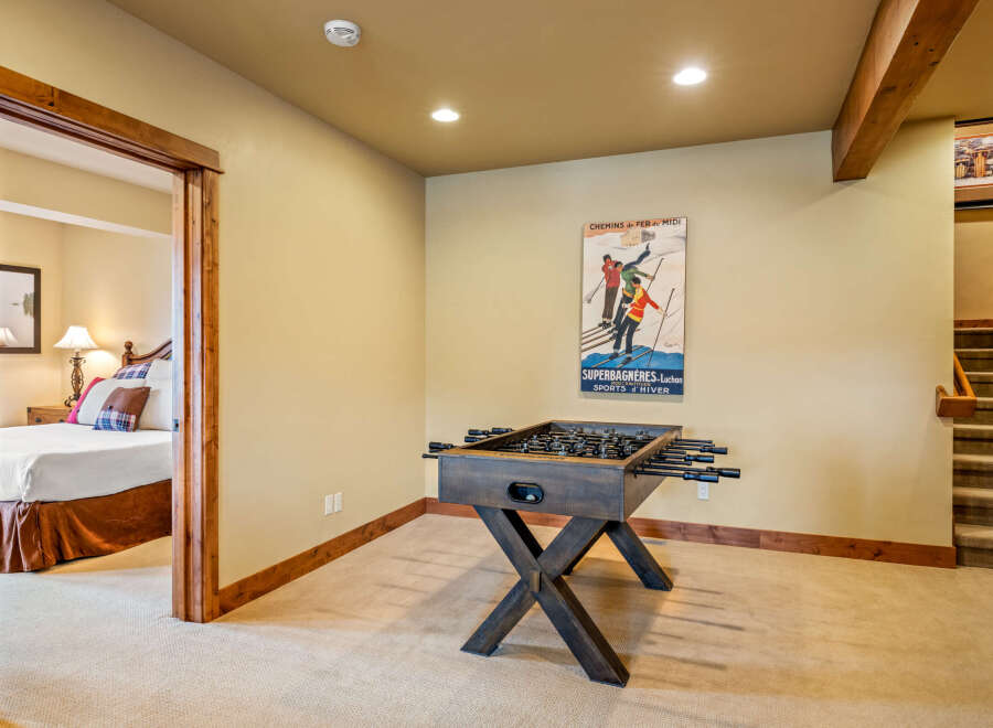 This basement living area offers a fun-filled game room with a foosball table, perfect for family entertainment.