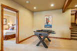 This basement living area offers a fun-filled game room with a foosball table, perfect for family entertainment.