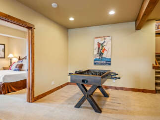 This basement living area offers a fun-filled game room with a foosball table, perfect for family entertainment.