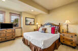 Experience rustic charm in this inviting bedroom, featuring a comfortable king-size bed adorned with plush pillows and a cozy plaid comforter.
