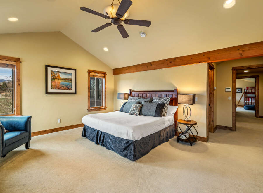 Experience ultimate comfort in this spacious master bedroom, featuring a luxurious king-size bed with plush bedding and decorative pillows.