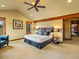 Experience ultimate comfort in this spacious master bedroom, featuring a luxurious king-size bed with plush bedding and decorative pillows.