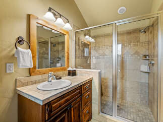 This beautifully appointed bathroom features a spacious walk-in shower with elegant tilework and a glass enclosure.