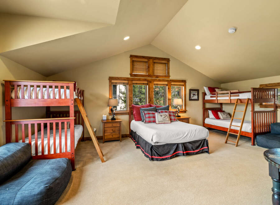 This spacious bedroom is perfect for families or groups, featuring two sturdy wooden bunk beds and a comfortable queen-size bed.