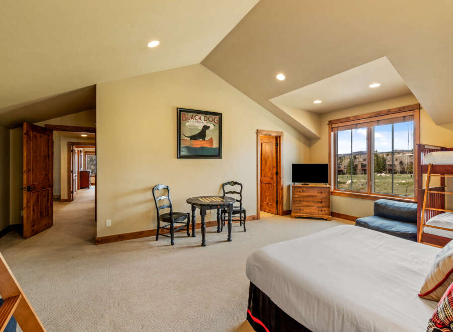 This spacious bedroom offers a comfortable retreat with a large bed and a bunk bed, perfect for families or groups.