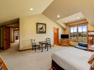 This spacious bedroom offers a comfortable retreat with a large bed and a bunk bed, perfect for families or groups.