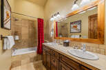 This charming bathroom features a spacious bathtub with a red checkered shower curtain, perfect for a relaxing soak.