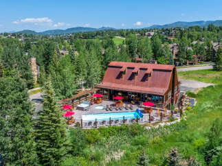 Experience luxury mountain living with this stunning property featuring a sparkling swimming pool and a relaxing hot tub, perfect for unwinding after a day of adventure.