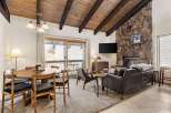 Experience cozy living in this charming mountain retreat, featuring a striking stone fireplace and a vaulted wood-beamed ceiling.