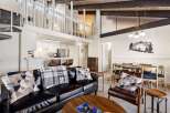 Experience modern living in this stunning loft-style condo, featuring a sleek black leather sofa and a cozy armchair perfect for relaxation.