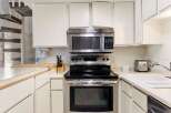 Discover this charming kitchen featuring a sleek stainless steel range and microwave, perfect for culinary adventures.