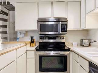 Discover this charming kitchen featuring a sleek stainless steel range and microwave, perfect for culinary adventures.