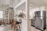 This charming kitchen features a sleek stainless steel refrigerator and a microwave above the stove.