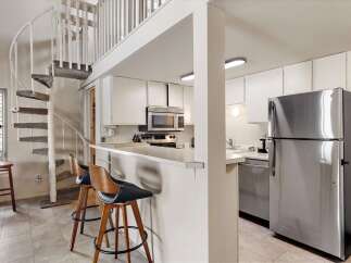 This charming kitchen features a sleek stainless steel refrigerator and a microwave above the stove.