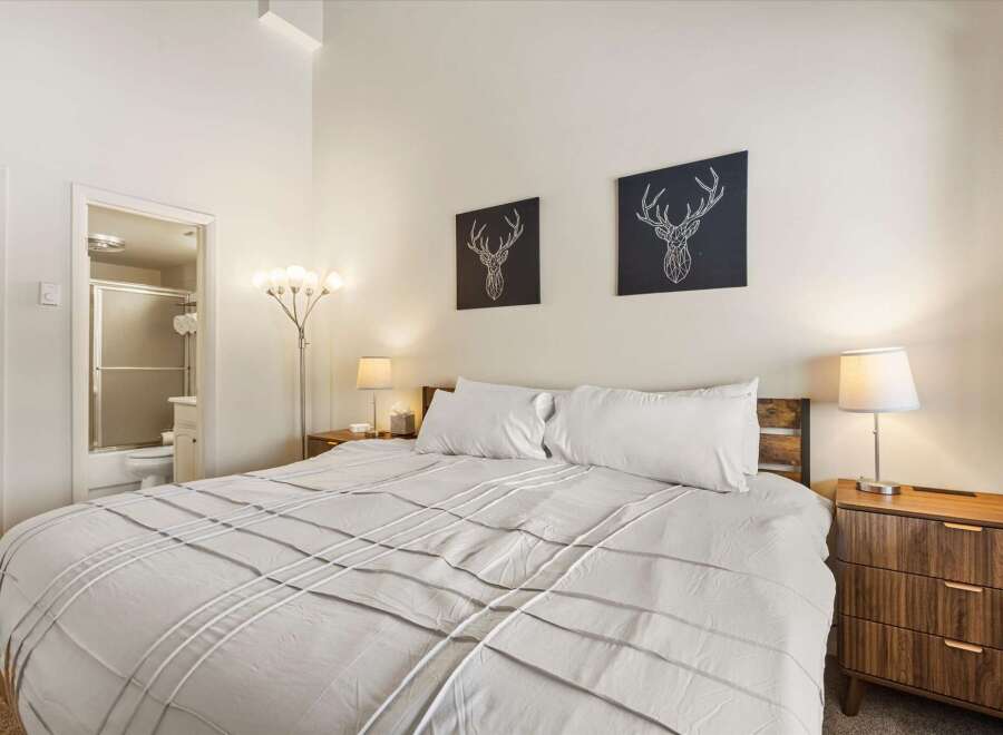 Experience comfort and style in this inviting bedroom, featuring a plush king-sized bed adorned with crisp white linens.
