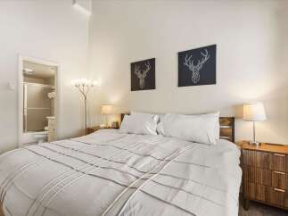 Experience comfort and style in this inviting bedroom, featuring a plush king-sized bed adorned with crisp white linens.