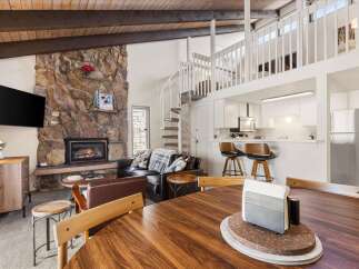 Experience cozy mountain living in this charming condo featuring a stunning stone fireplace and a spiral staircase leading to a loft.