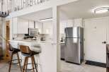 This charming kitchen features a sleek stainless steel refrigerator and a microwave oven above the stovetop.