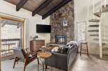 Cozy living room featuring a striking stone fireplace and a large flat-screen TV.