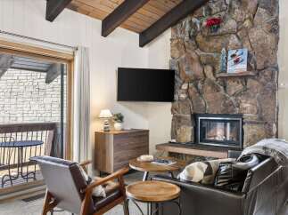 Cozy up by the stunning stone fireplace in this inviting living room, perfect for relaxing after a day on the slopes.