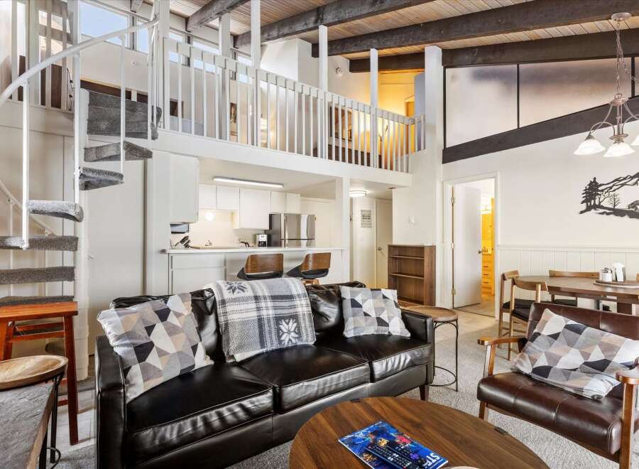 Experience modern living in this stunning loft-style condo, featuring a dramatic spiral staircase leading to a spacious loft area.