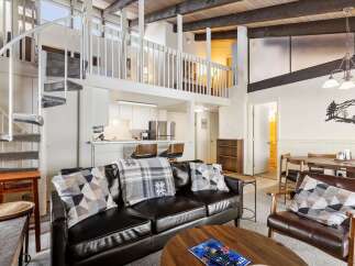 Experience modern living in this stunning loft-style condo, featuring a dramatic spiral staircase leading to a spacious loft area.