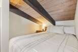 Experience cozy comfort in this charming bedroom, featuring a plush white duvet and crisp white pillows.