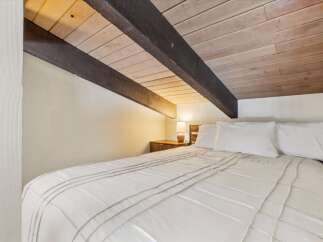 Experience cozy comfort in this charming bedroom, featuring a plush white duvet and crisp white pillows.