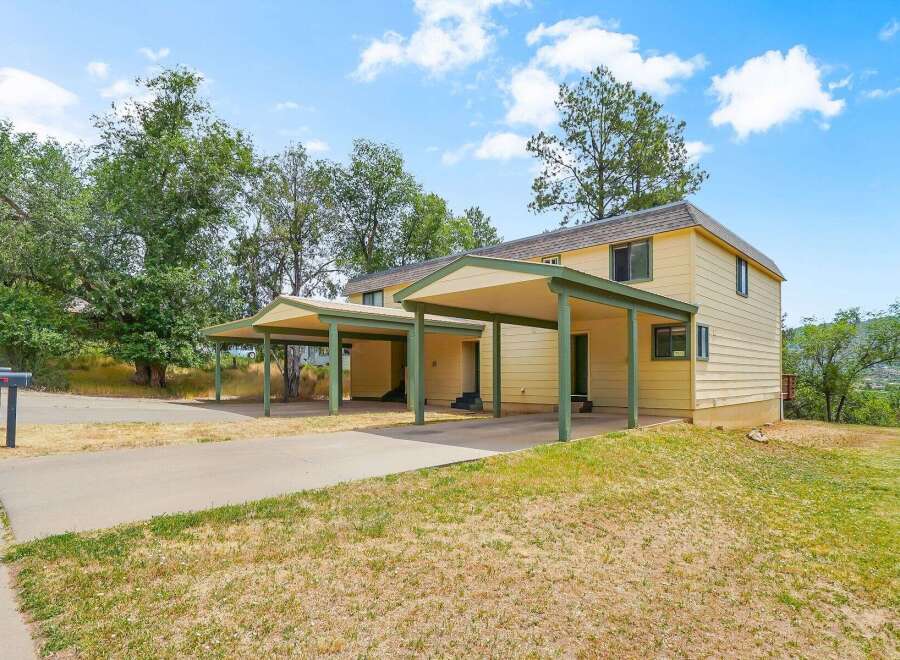Discover this charming property featuring a bright yellow exterior and convenient covered parking.