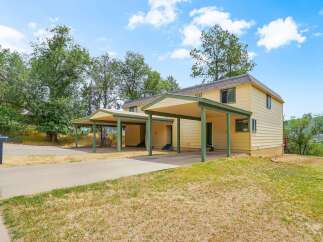 Discover this charming property featuring a bright yellow exterior and convenient covered parking.