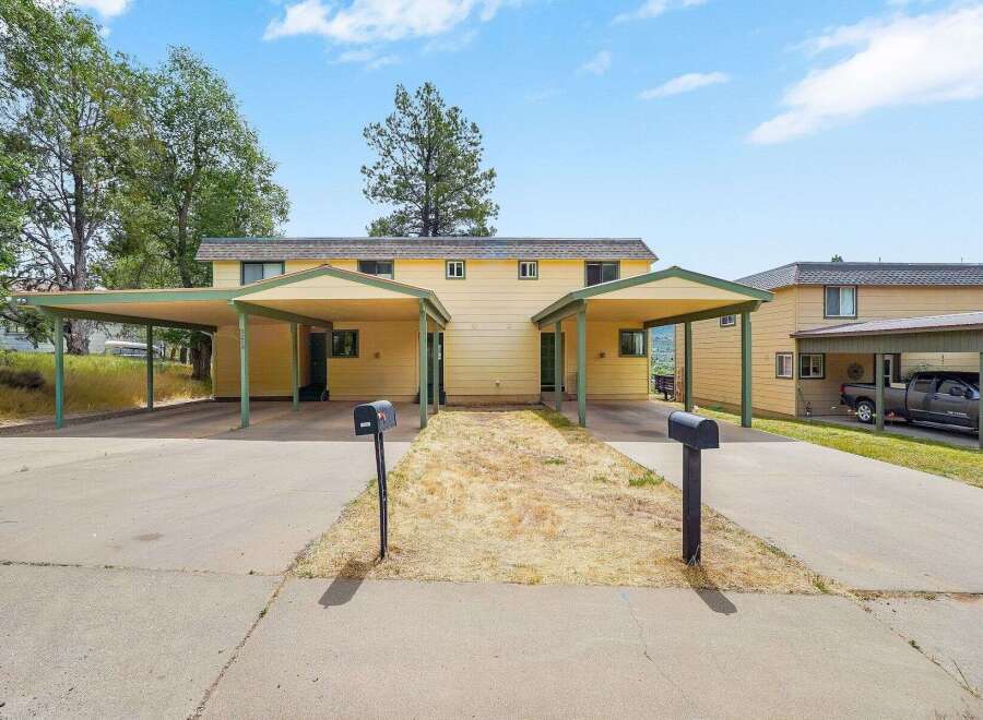 Discover comfortable living in this charming duplex featuring two distinct units, each with its own covered carport for convenient parking.