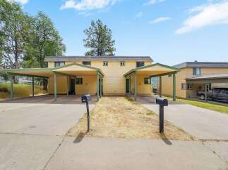Discover comfortable living in this charming duplex featuring two distinct units, each with its own covered carport for convenient parking.